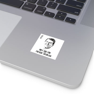 Laptop with a sticker featuring a black and white portrait and text on a white background