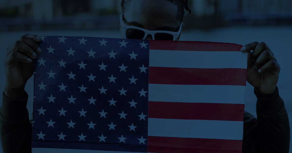 Person holding an American flag with a blurred background
